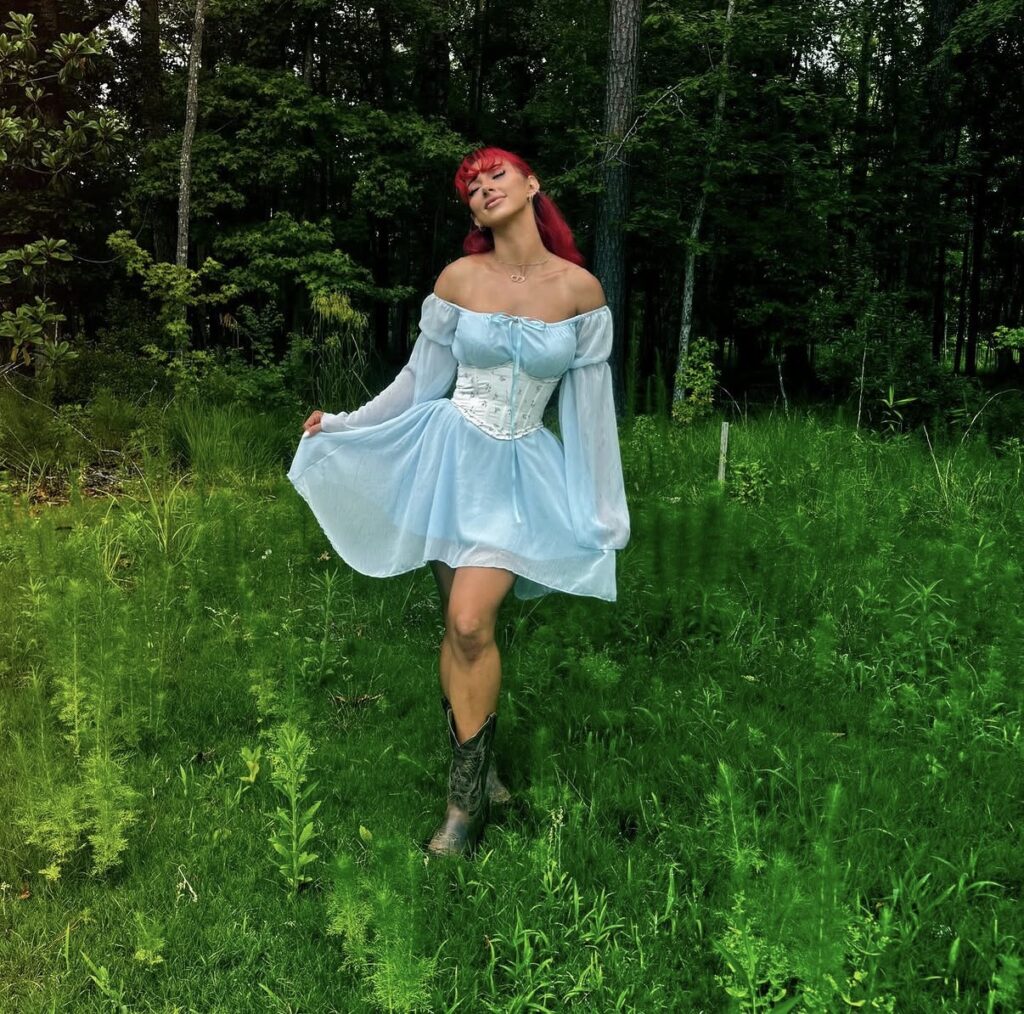 Nala Ray outdoor meadow portrait in blue dress with glamorous influencer style