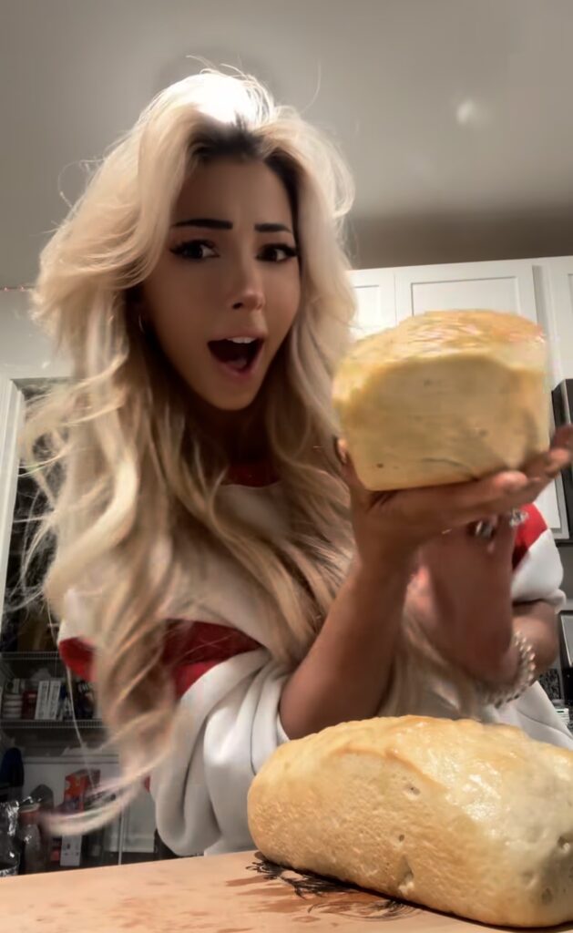 Nala Ray playful kitchen portrait holding bread with luxury influencer vibe