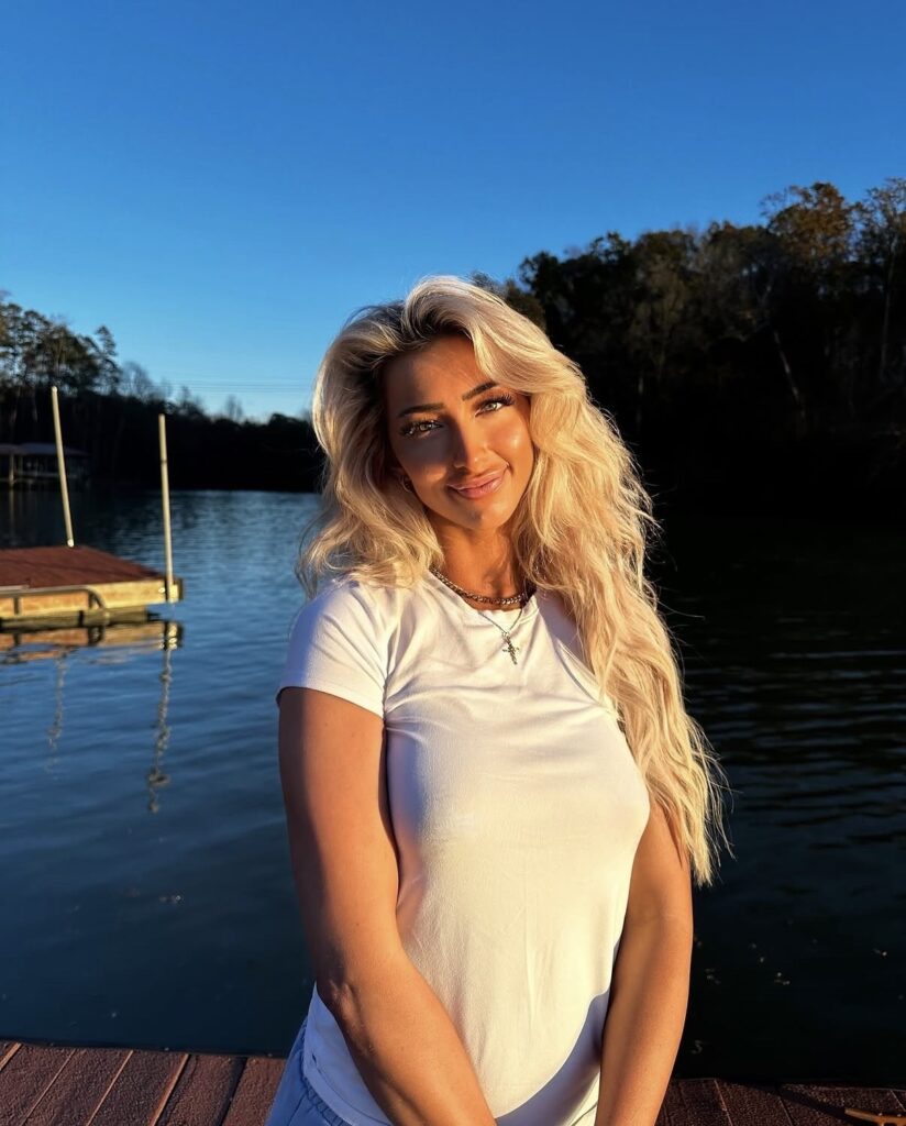 Nala Ray lakeside portrait in white outfit with luxury influencer aesthetic