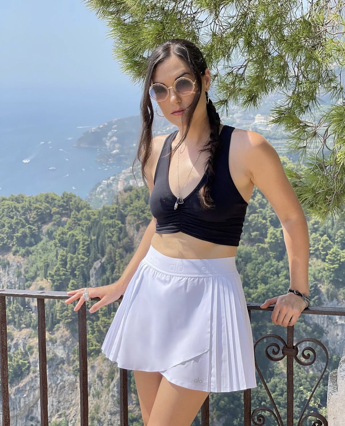 Sasha Grey posing outdoors in sporty luxury outfit with scenic travel background